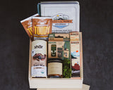 Gift basket with snacks, a journal, and a book on a dark background