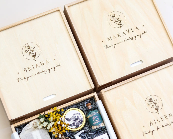 Three wooden gift boxes with skincare products and decorative elements on a light background