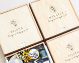 Three wooden gift boxes with skincare products and decorative elements on a light background