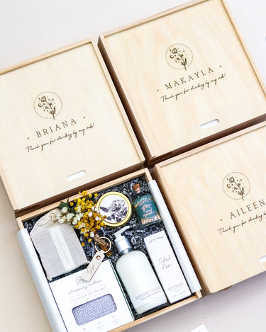 Four wooden gift boxes with skincare products and decorative elements on a light background